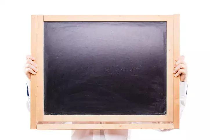 Boy holding blackboard isolated on white backdrop