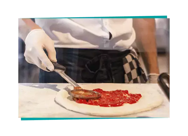 man in gloves making pizza