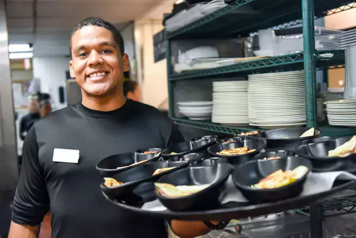 Smiling afro-caribbean waiter